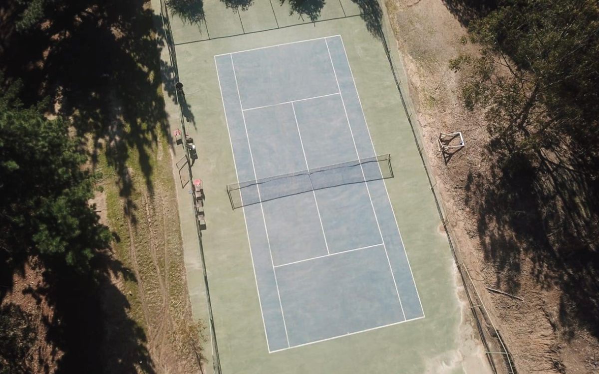 Cancha de tenis rodeada de bosque