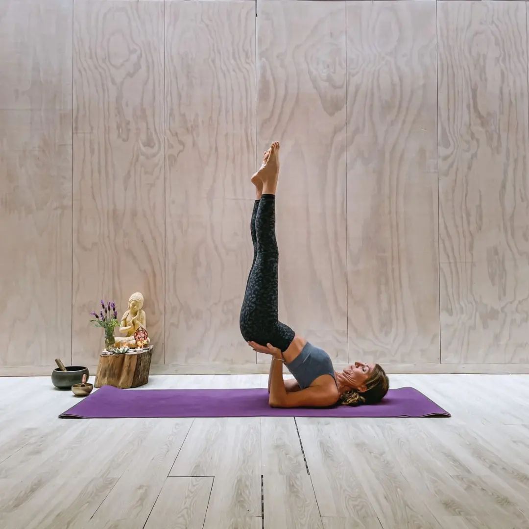 Postura de yoga junto al ventanal