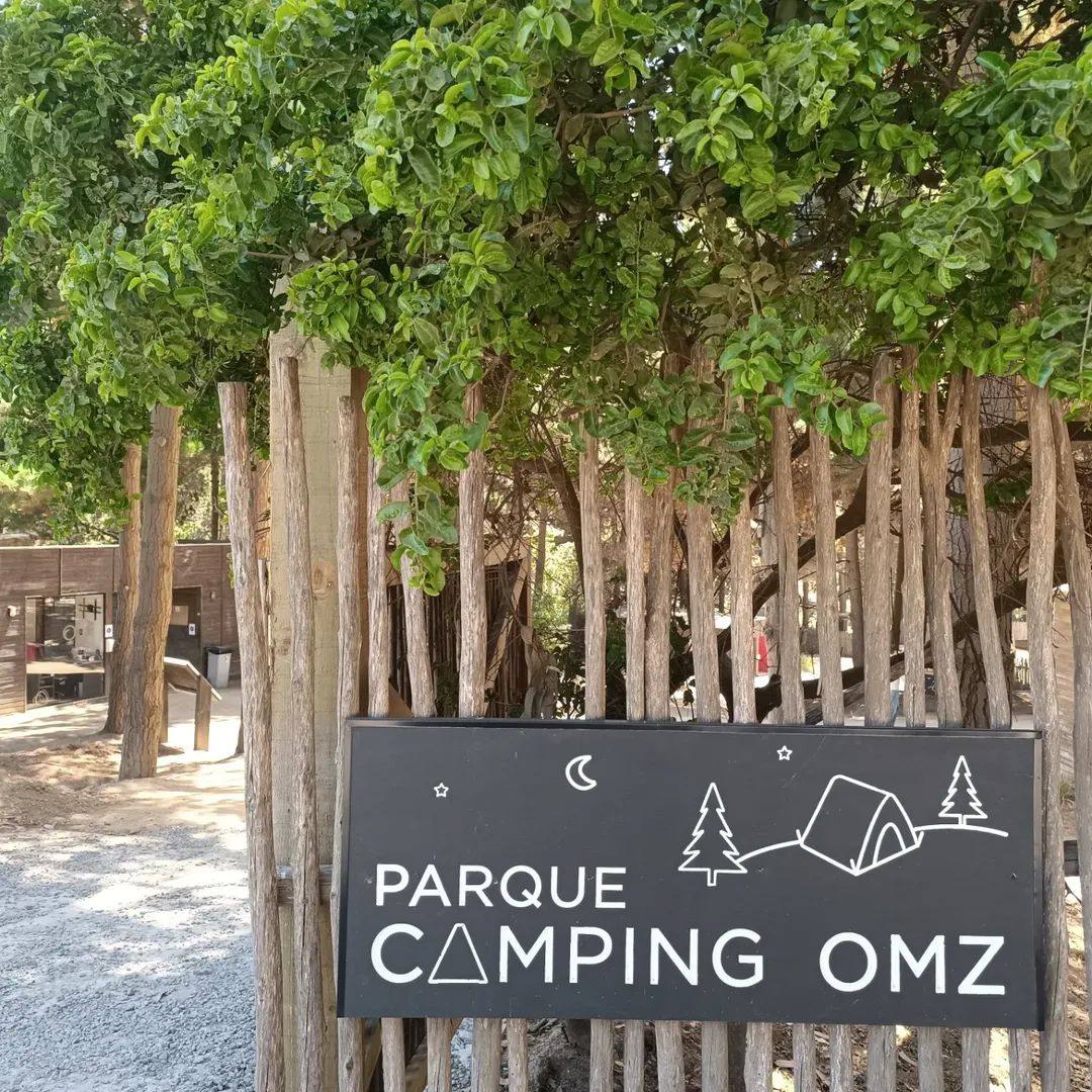 Cartel de entrada Parque Camping OMZ entre los árboles